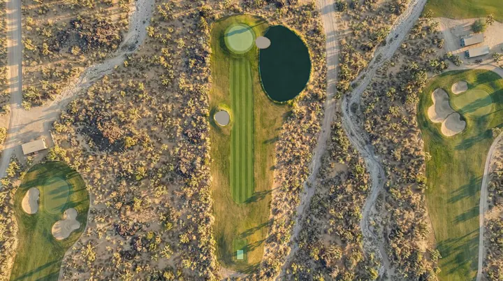 Coyote Flat from the air: a fairway in high desert scrub with a pond beside the green and dirt tracks across the sand.
