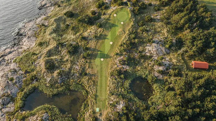 Stenvik Links from the air: a fairway through pine and juniper, with granite, a pond and the sea at its edge.